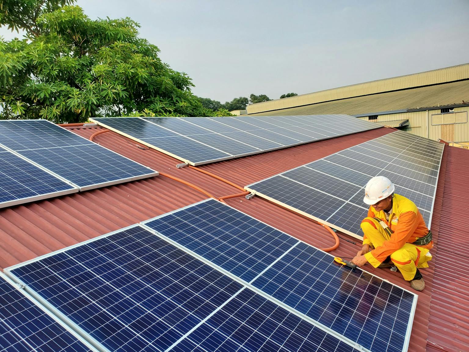 Solarthermie und Photovoltaik: Techniker wartet Solaranlage auf Hausdach