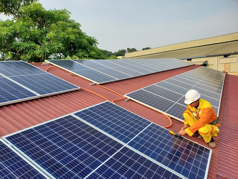 Solarthermie und Photovoltaik: Techniker wartet Solaranlage auf Hausdach